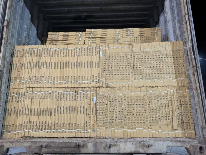 Tile boxes stacked to the roof of a shipping container